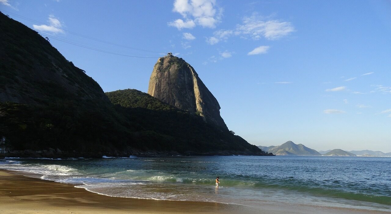 Vista incrível do Costão do Pão de Açúcar, na Urca, Rio de Janeiro, com montanhas e o mar ao fundo.